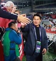 　サポーターとタッチを交わす神戸・吉田孝行監督（撮影・立川洋一郎）