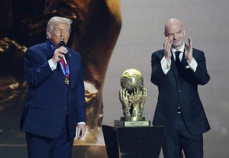 サッカーＷ杯北中米３カ国大会の組み合わせ抽選会でＦＩＦＡが新設した「平和賞」を受賞し、あいさつするトランプ米大統領。右はインファンティノ会長＝５日、米ワシントン（共同）