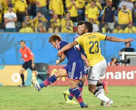 　Ｗ杯ブラジル大会のコロンビア戦で、カルロス・バルデス（右）のマークを受けながらシュートを放つ柿谷＝２０１４年