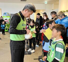 　参加者のサインに応じるカズ