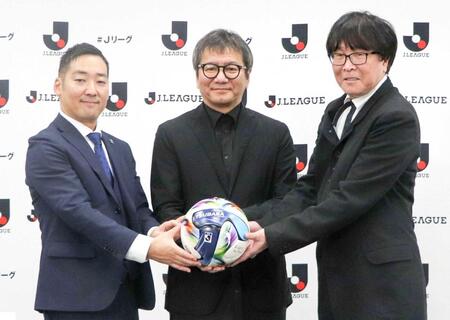 　公式試合球を手に写真に納まる高橋陽一氏（右）ら