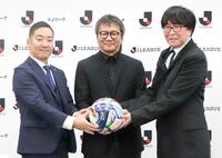 　公式試合球を手に写真に納まる高橋陽一氏（右）ら