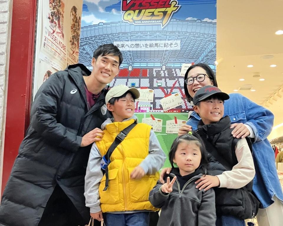 　グッズショップ前で神戸ファンと写真に収まる山川哲史（撮影・中野裕美子）