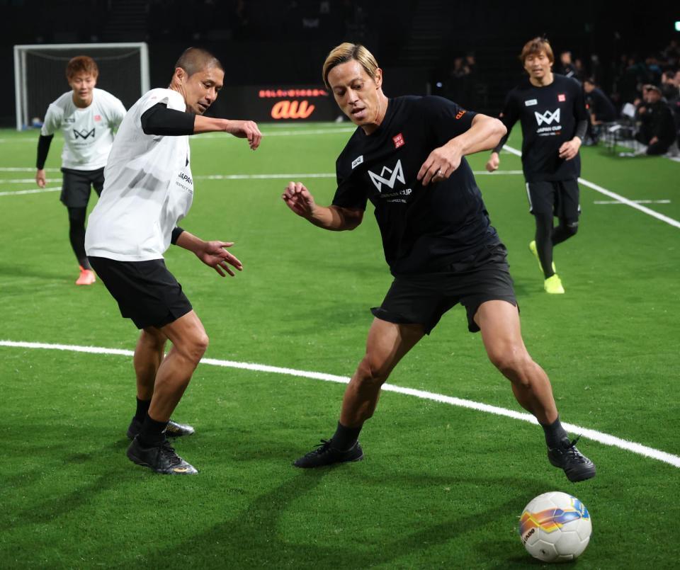 　坪井慶介氏と競り合う本田圭佑（撮影・金田祐二）