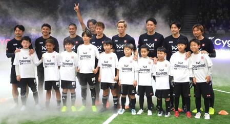 　子どもたちと記念撮影する（左から）家長、宇佐美、坪井氏、中沢氏、柿谷氏、本田、権田、内田氏、乾（撮影・金田祐二）