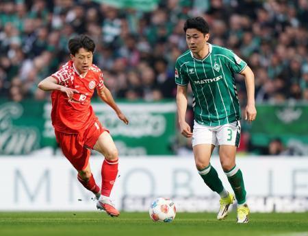 　マインツ戦で競り合うブレーメンの菅原由勢（右）＝１５日、ブレーメン（ゲッティ＝共同）