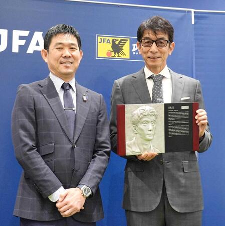 　レリーフ盾を手に笑顔を見せる井原正巳さん。左は森保監督