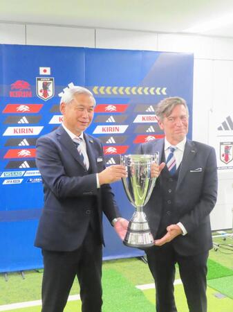 アジア杯優勝トロフィーを手に撮影に応じる佐々木則夫女子委員長（左）とニルス・ニールセン監督