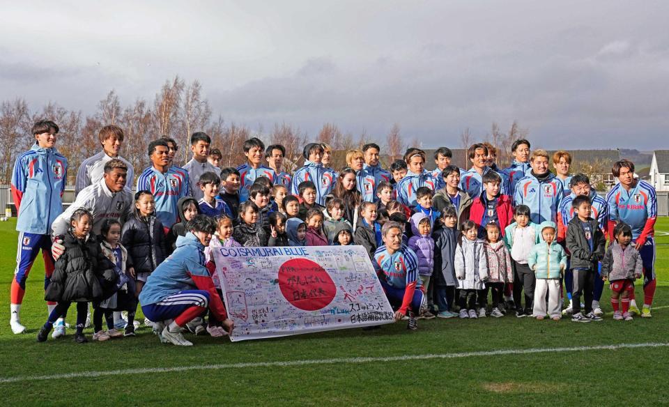 　現地の日本人らと写真に納まる選手たち（共同）