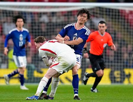 後半、激しく競り合う小川（右）＝ロンドン（共同）