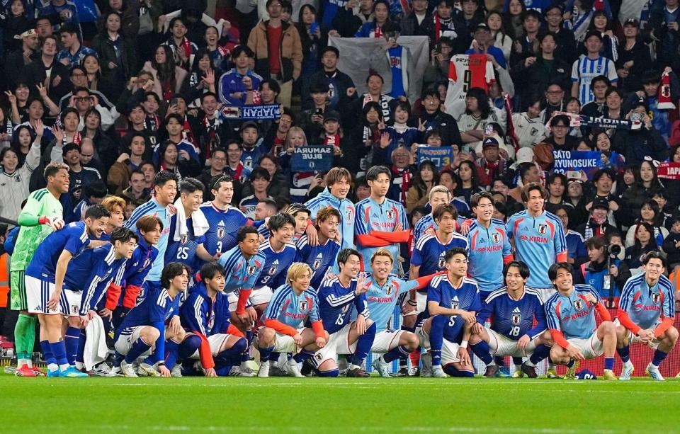 　サッカー国際親善試合でイングランドから初勝利を挙げ、サポーターと写真に納まる日本代表の選手たち＝３月３１日、ロンドンのウェンブリー競技場（共同）