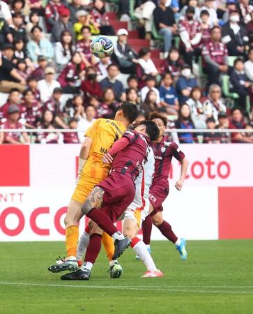 　後半、ゴール前で交錯するトゥーレル（左）と神戸・ＧＫ前川（左）