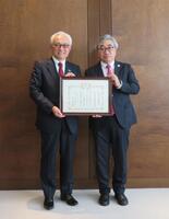 日本赤十字社の紀野修一血液事業本部長（右）から賞状を贈られた明治安田の根岸秋男会長