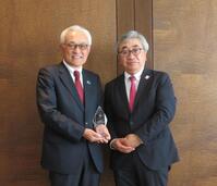 日本赤十字社の紀野修一血液事業本部長（右）から記念の盾を贈られた明治安田の根岸秋男会長