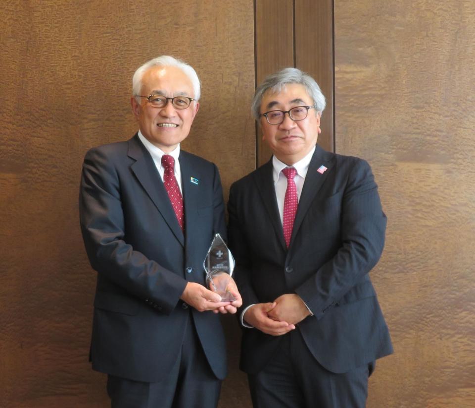 日本赤十字社の紀野修一血液事業本部長（右）から記念の盾を贈られた明治安田の根岸秋男会長