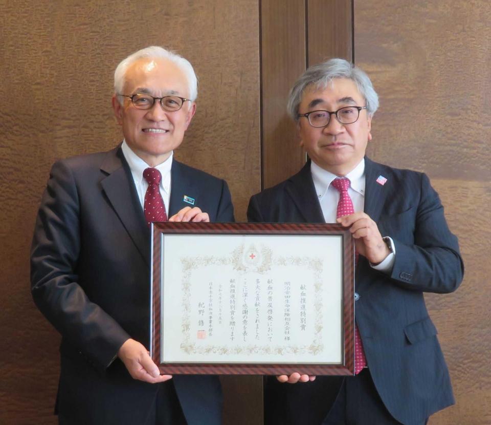 　日本赤十字社の紀野修一血液事業本部長（右）から賞状を贈られた明治安田の根岸秋男会長