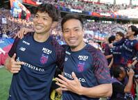 仲間から「５回目あるよ！」と声をかけられ５本の指を広げて笑顔を見せるＦＣ東京・長友佑都（中央）。左は森重真人（撮影・吉澤敬太）