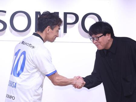 高橋陽一氏（右）と握手をする中田英寿氏＝東京・グレイドパーク新宿駅前（撮影・佐々木彰尚）