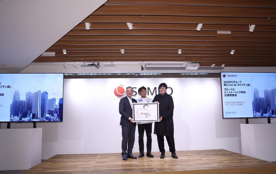 キービジュアルを手にする（左から）ＳＯＭＰＯホールディングスグループＣＥＯ・奥村幹夫氏、中田英寿氏、高橋陽一氏＝東京・グレイドパーク新宿駅前（撮影・佐々木彰尚）