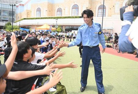 千葉県警の少年犯罪実行者募集情報加担防止広報官の制服姿でファンとタッチを交わすサッカ日本代表のＭＦ中村敬斗（撮影・開出牧）