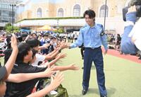 千葉県警の少年犯罪実行者募集情報加担防止広報官の制服姿でファンとタッチを交わすサッカ日本代表のＭＦ中村敬斗（撮影・開出牧）