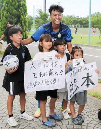 　「がんばれ！熊本」と書かれた紙を持つ子どもらと写真に納まる、大津高の西本瑛司（奥）