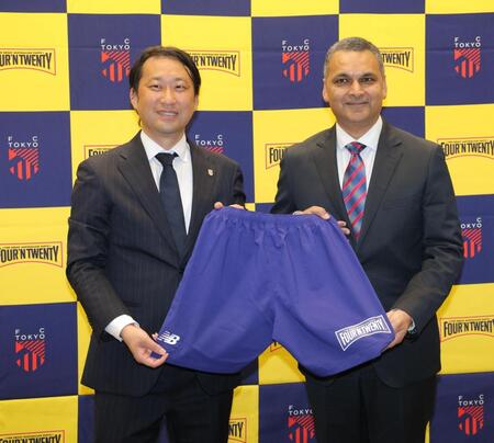 ロゴの入ったユニホームを持つＦＣ東京・白井英介社長（左）とパティーズフードグループ・アナンド・スルジパル氏（撮影・西岡正）