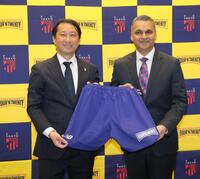 ロゴの入ったユニホームを持つＦＣ東京・白井英介社長（左）とパティーズフードグループ・アナンド・スルジパル氏（撮影・西岡正）