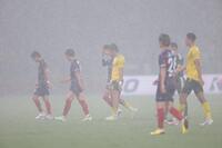 雷の危険で引き揚げる両チームイレブン（撮影・西岡正）