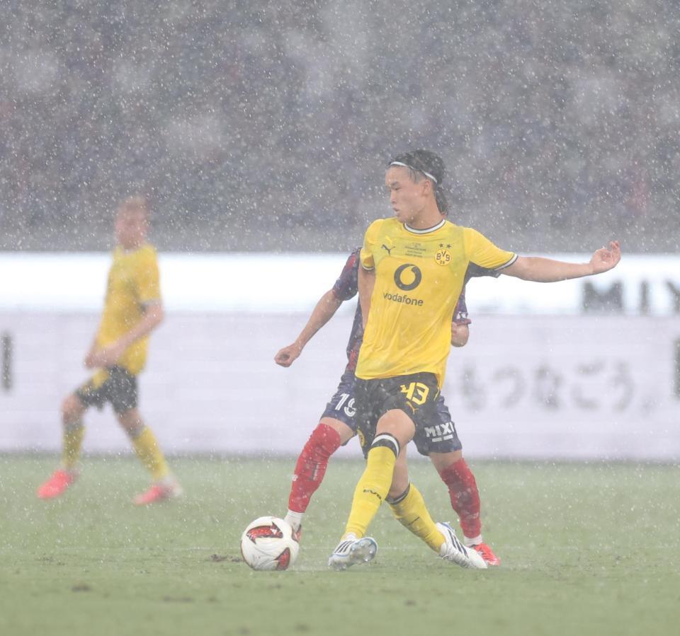 前半、激しい雨の中を競り合うドルトムント・山本天翔（撮影・西岡正）