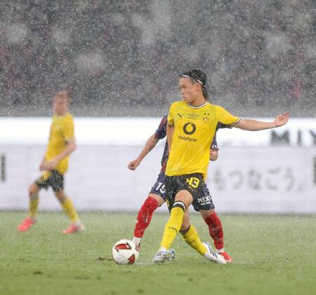 　前半、激しい雨の中を競り合うドルトムント・山本（撮影・西岡正）
