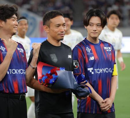 櫻井海音（右）らからＷ杯出場を労われ花束を受け取るＦＣ東京・長友佑都（中央）＝撮影・吉澤敬太