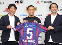 ＦＣ東京と再契約し、小原光城ＧＭ（左）、白井英介社長（右）と笑顔を見せる長友佑都（撮影・吉澤敬太）