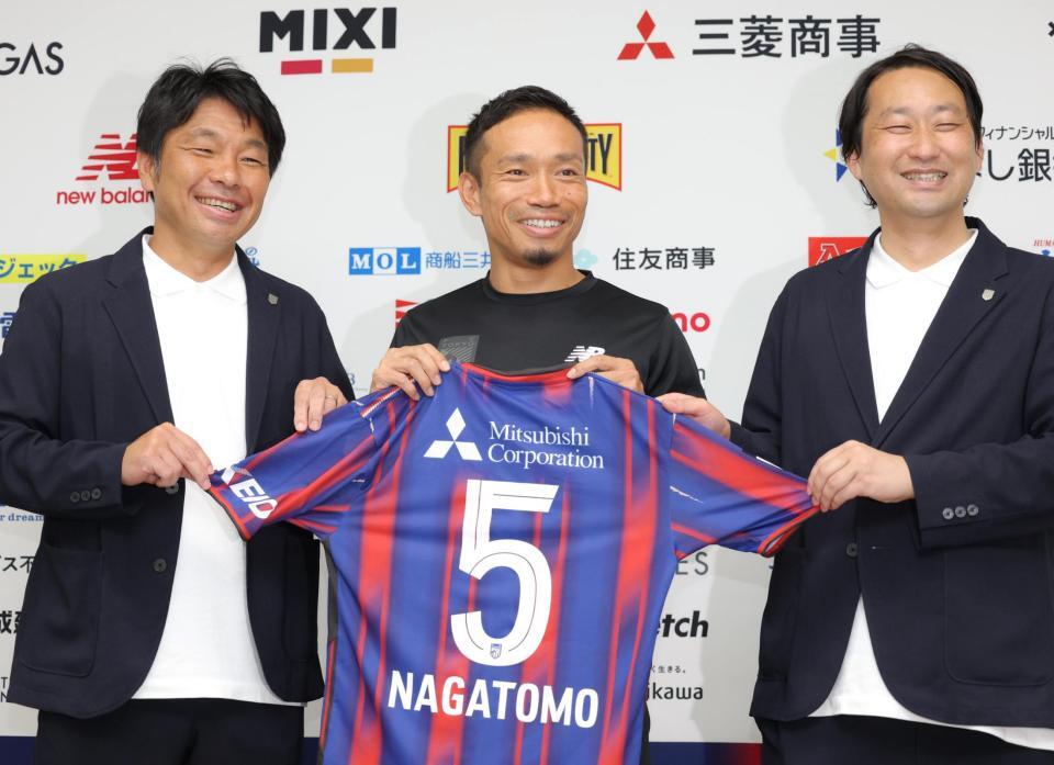 ＦＣ東京と再契約し、小原光城ＧＭ（左）、白井英介社長（右）と笑顔を見せる長友佑都（撮影・吉澤敬太）