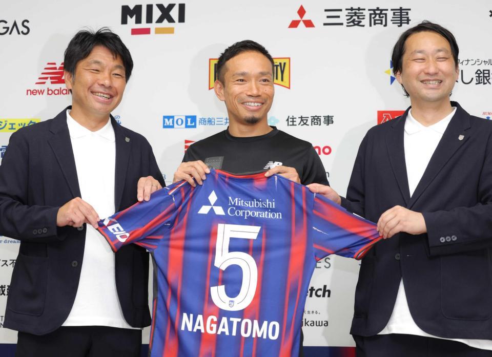 　ＦＣ東京と再契約し、小原光城ＧＭ（左）、白井英介社長（右）と笑顔を見せる長友佑都＝味の素スタジアム（撮影・吉澤敬太）