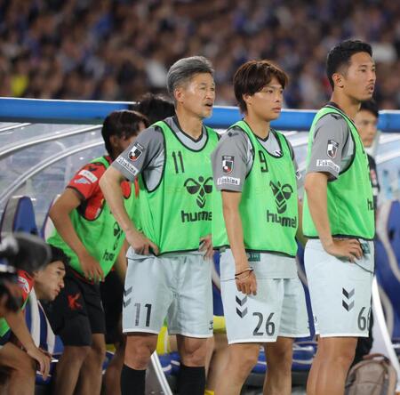 後半、ベンチから身を乗り出して試合を見つめる福島・三浦知良（中央）＝撮影・吉澤敬太