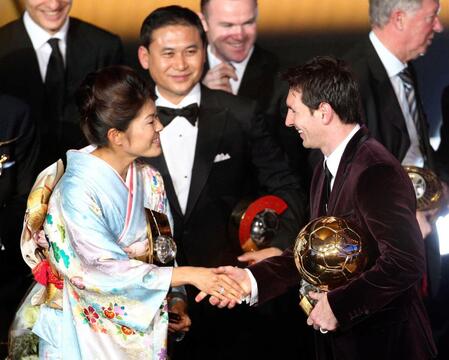 ２０１２年１月、ＦＩＦＡの世界年間最優秀選手に選ばれ、アルゼンチン代表のメッシ（右）と握手する澤穂希選手。中央左は佐々木則夫監督＝スイス・チューリヒ（ＡＰ＝共同）