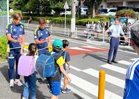 横断歩道で子どもたちを見守った横浜ＭのＦＷ宮市亮（右）とＤＦ松原健