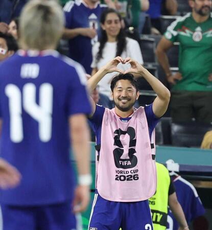 Ｗ杯チュニジア戦で、ゴールを決めた伊東純也にハートポーズを作る菅原由勢＝６月２０日、モンテレイ