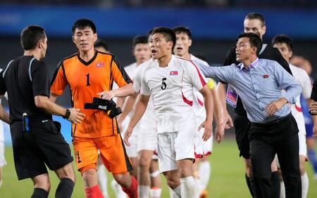 日本に敗れ、試合終了後に審判に詰め寄る北朝鮮選手たち（２３年１０月１日撮影）＝共同
