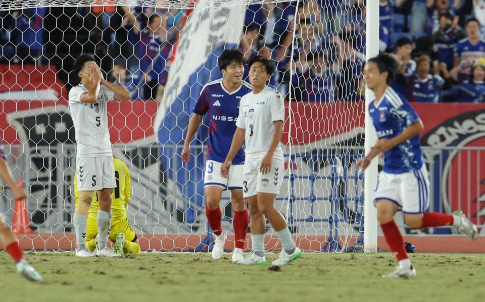 後半、横浜Ｍ・天野純（手前右）に勝ち越しゴールを決められ手で顔を覆う京産大・西村想大（左）ら＝撮影・吉澤敬太