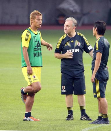 　練習終了後、長時間話し込むザッケローニ監督（右）と本田