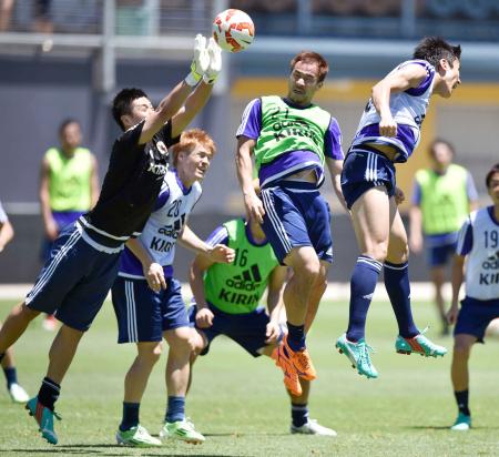 　サッカーのアジア杯に向けた日本代表の練習で、クロスに飛び込む岡崎（中央）と川島（左）＝共同