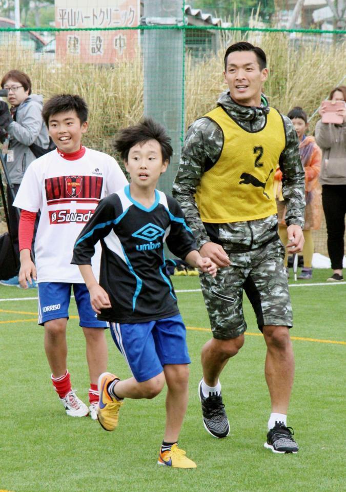 　サッカー教室で参加者と体を動かすＪ１浦和の槙野智章選手（右）