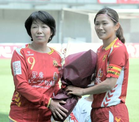 　１００試合出場のセレモニーで母・千奈美さん（左）から花束を贈られる川澄