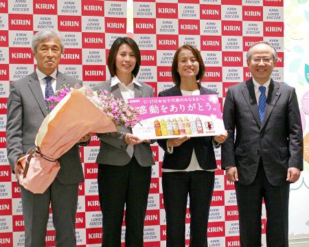 　Ｕ-１７日本女子代表の優勝報告をし、キリンの磯崎社長（右）から報奨品を受け取った高倉監督（右から２人目）