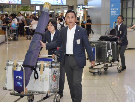 　韓国の仁川国際空港に到着したサッカー女子日本代表の佐々木監督。左は猶本（共同）