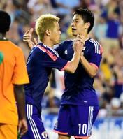 　後半、決ち越しゴールを決め、香川真司（右）とタッチを交わす本田圭佑＝レイモンド・ジェームス・スタジアム
