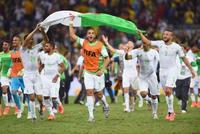 　決勝トーナメント進出を決め、国旗を手に喜ぶアルジェリアイレブン＝クリチバ（ゲッティ＝共同）