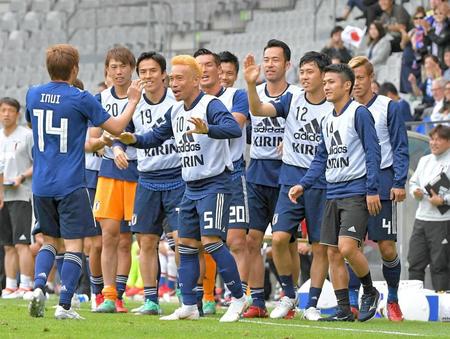 　後半、２点目のゴールを決めた乾（左）を笑顔で迎える日本代表イレブン